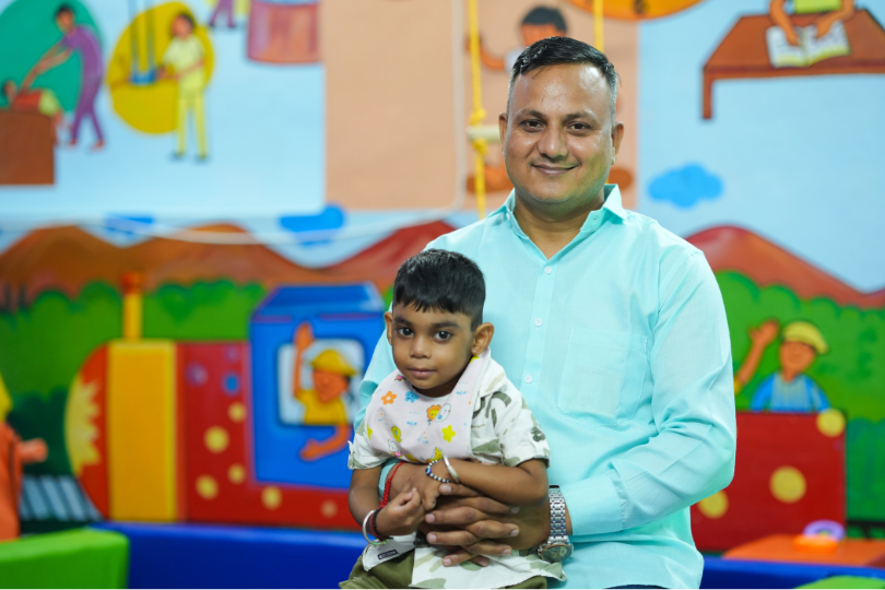 A middle-aged man with a child on his laps