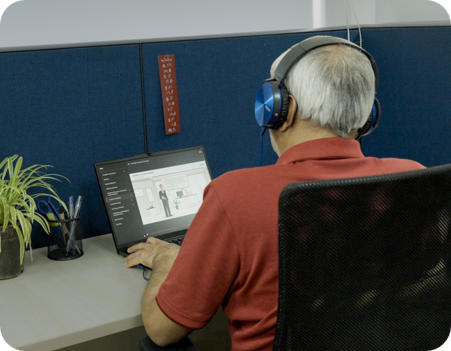 A man sitting at his desk in front of his laptop